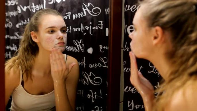 十几岁的女孩在浴室用肥皂擦脸