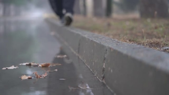 秋天下雨后的小巷在秋天，人们的脚沿着人行道行走