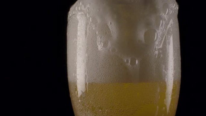 啤酒泡沫倒在杯子边缘