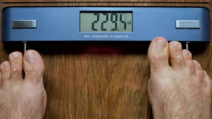 严重超重的人在数字秤上称自己。光着脚站在体重秤上的人。暴饮暴食糖尿病。