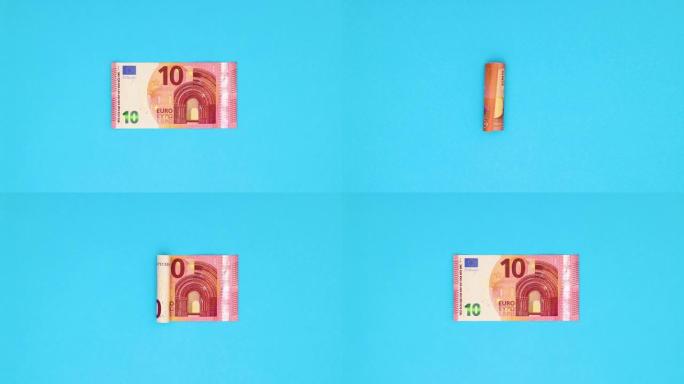 滚动的十欧元钞票出现并在蓝色背景上展开-停止运动