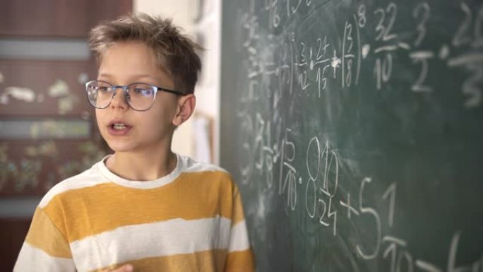 可爱的小男孩在数学课上解释分数计算
