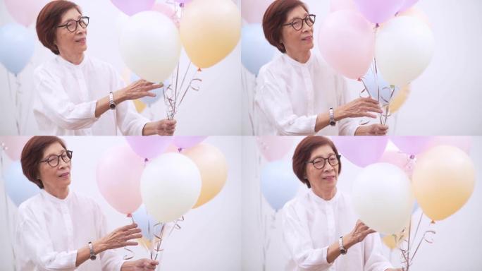 带气球的快乐亚洲高级女性。老年人生日或周年派对概念