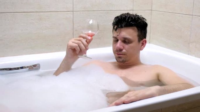 醉汉喝着红酒，在浴缸里睡着了。