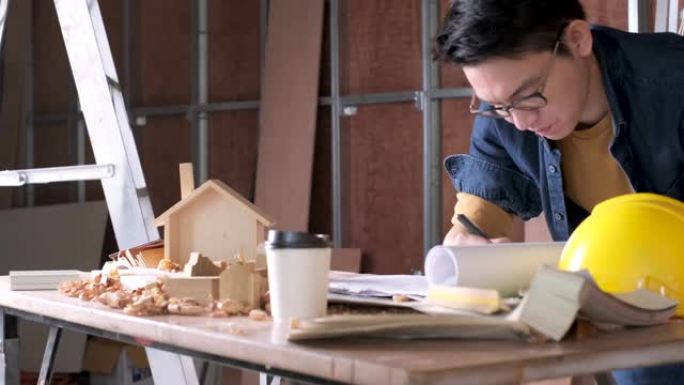 聪明迷人的方便眼镜亚洲男性工匠或室内设计师焦点木材在现场施工家庭室内设计房屋翻新和改进概念