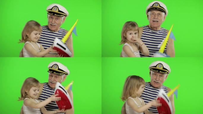 年长的水手祖父和孙女一起玩。快乐的小孩