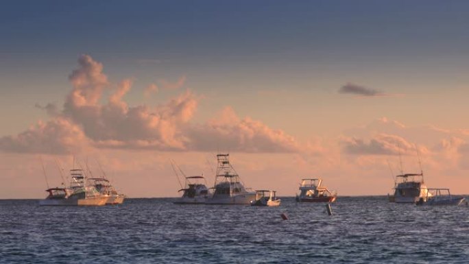 在海洋中航行双体船、帆船和快艇。加勒比海上空的日出。