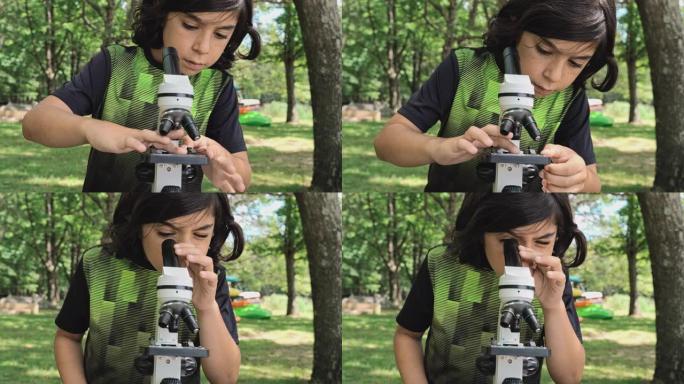 在阳光明媚的夏日，在湖岸的户外，用显微镜工作的9岁男孩-准备标本，观察和学习自然。4K UHD视频片