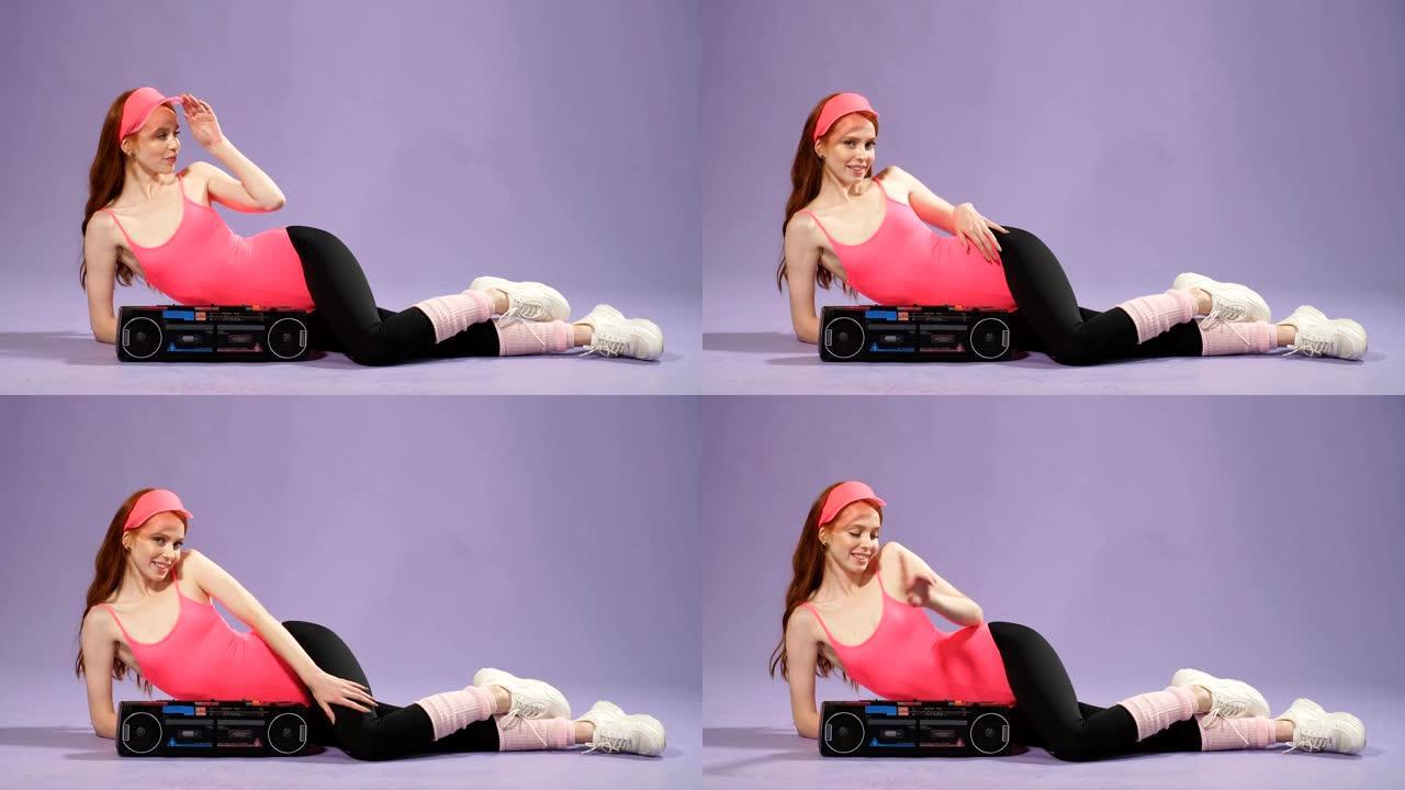 快乐的运动女人在健身训练后坐着，关闭便携式音频播放器