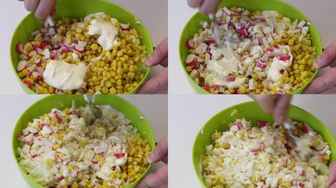 一个男人做沙拉。他拿着勺子，将切碎的蟹棒，玉米，北京白菜和蛋黄酱混合在一个容器中。