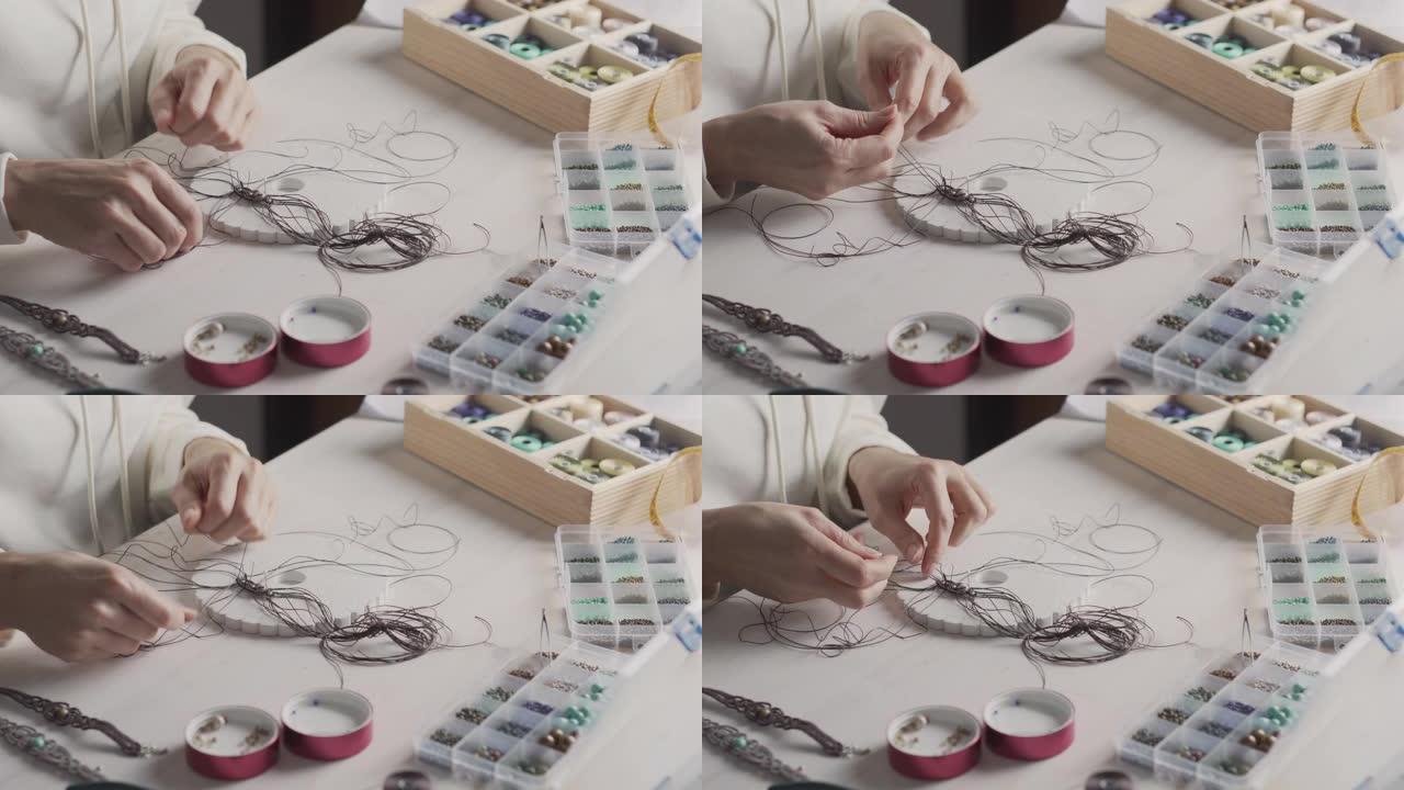 生活方式的概念，在家工作以重塑您的生活: 女人的手的特写镜头，用石珠和工具在轻木桌上制作macram