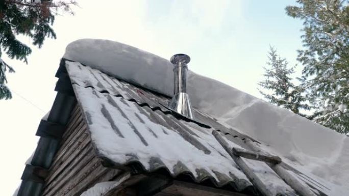 西伯利亚村庄一栋居民楼屋顶上的烟囱冒烟的特写镜头。西伯利亚一所房子屋顶上的金属烟囱。4K