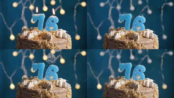 蓝色背景上有76号蜡烛的生日蛋糕。蜡烛吹灭了。慢动作和特写视图