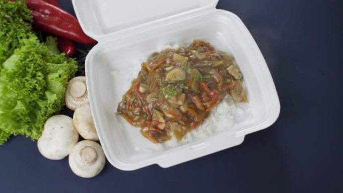 将外卖食品包装在聚苯乙烯泡沫塑料盒中。新鲜送餐包米饭和蔬菜