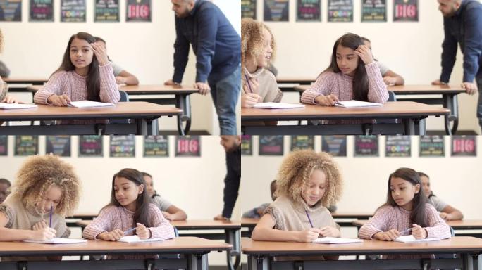 用镜头摇摄两个小女孩在课堂上分享笔记