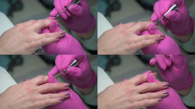 美甲美容师用闪光指甲油覆盖客户指甲的特写