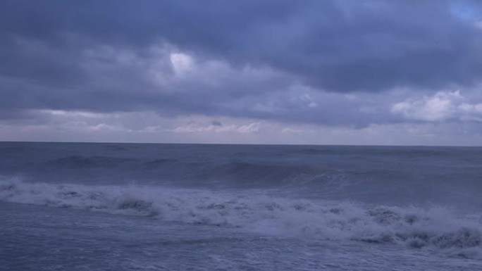 大浪冲向海岸线。喷涂泡沫。