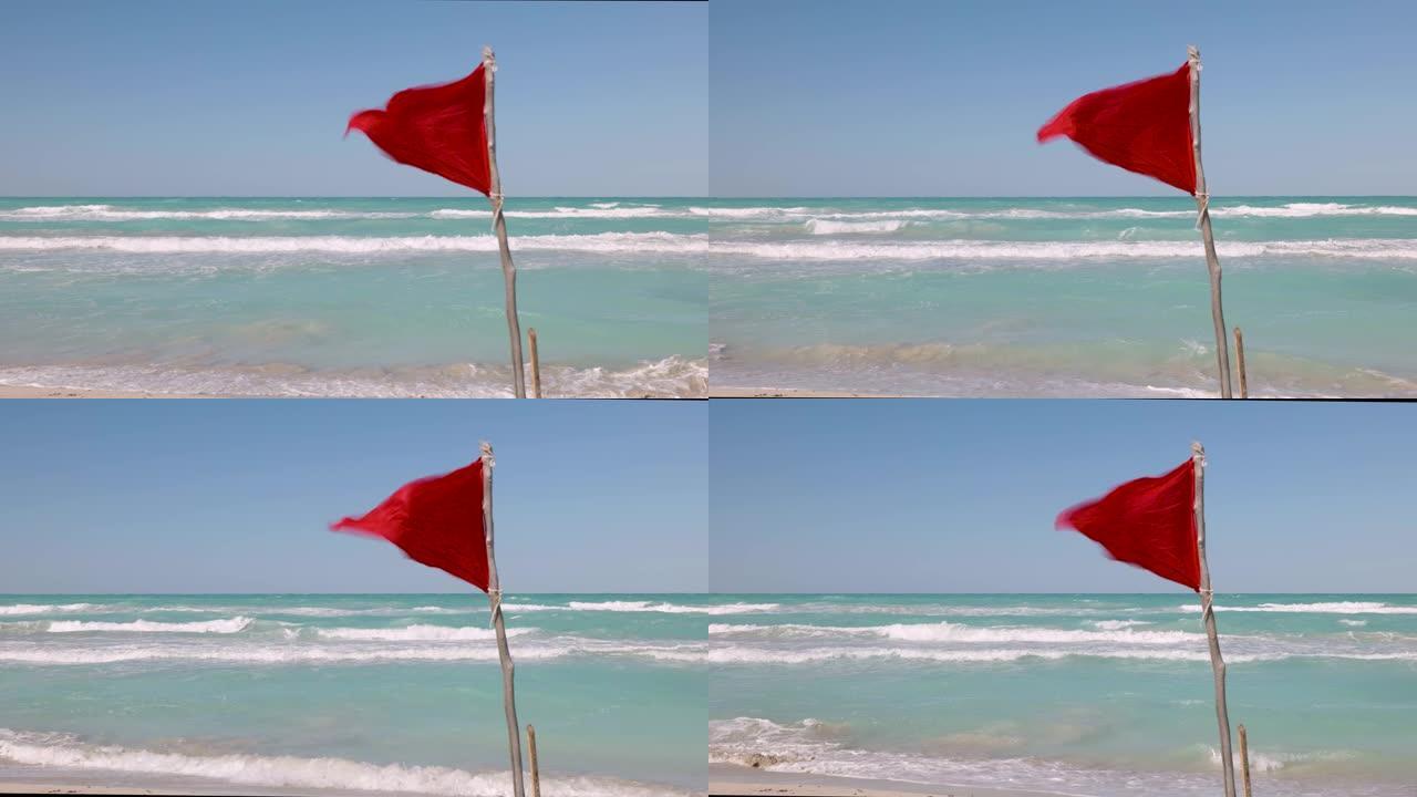 红色警告旗在海滩上狂风飘扬，以提醒人们不要游泳