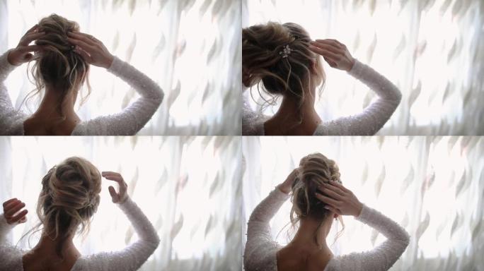 年轻女子站在窗户旁，在婚礼前调整金发