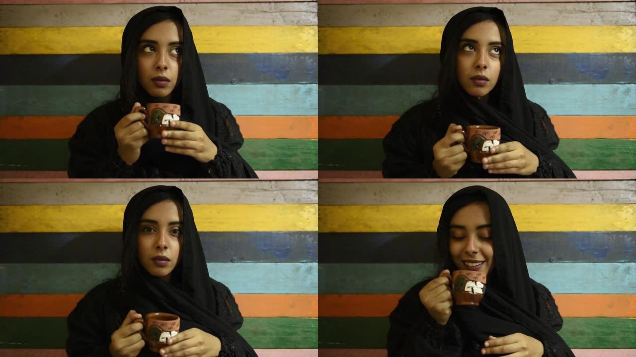 年轻漂亮的穆斯林女孩戴着头巾拿着陶瓷茶杯