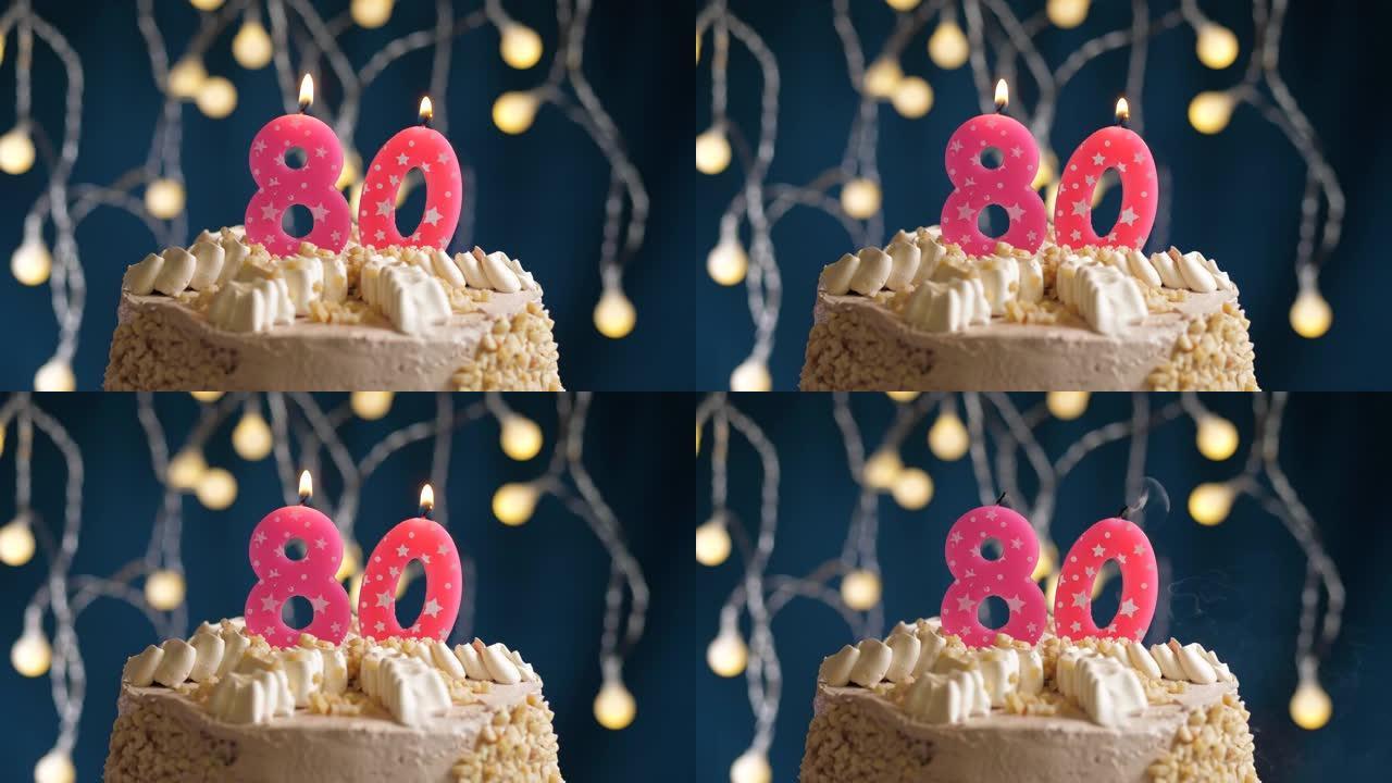蓝色背景上有80号粉色蜡烛的生日蛋糕。蜡烛吹灭了。慢动作和特写视图
