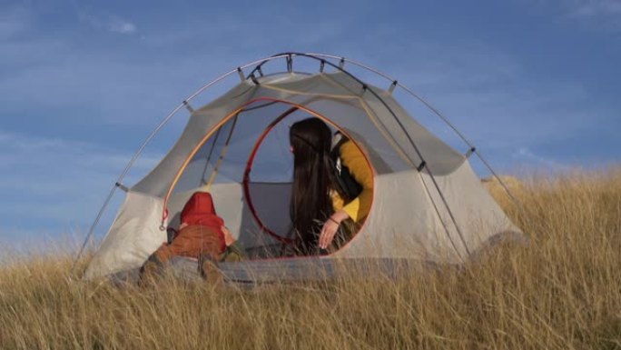 快乐旅行家单身母亲和孩子在旅行帐篷里玩耍