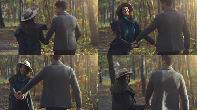 美丽的夫妇走在秋天的公园。慢动作