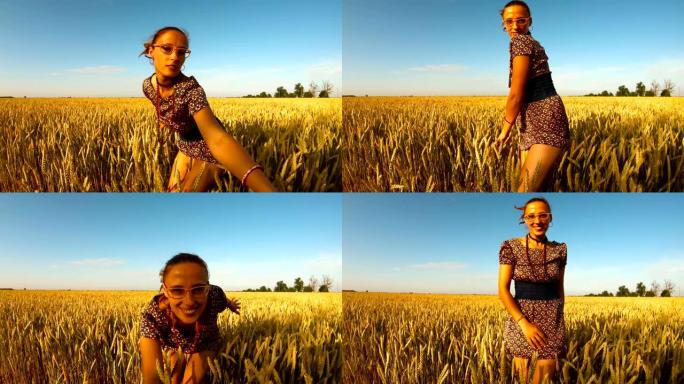 美丽的女孩将双手放在田间的黄色麦穗上微笑在相机蓝天和阳光明媚的日子里看着