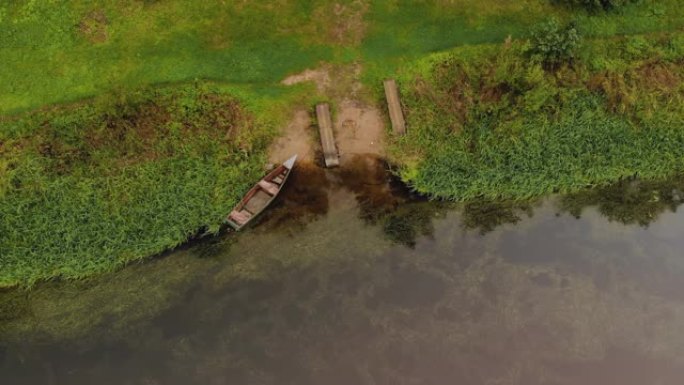 一艘停泊在河的沙质河岸上的木制渔船的俯视图