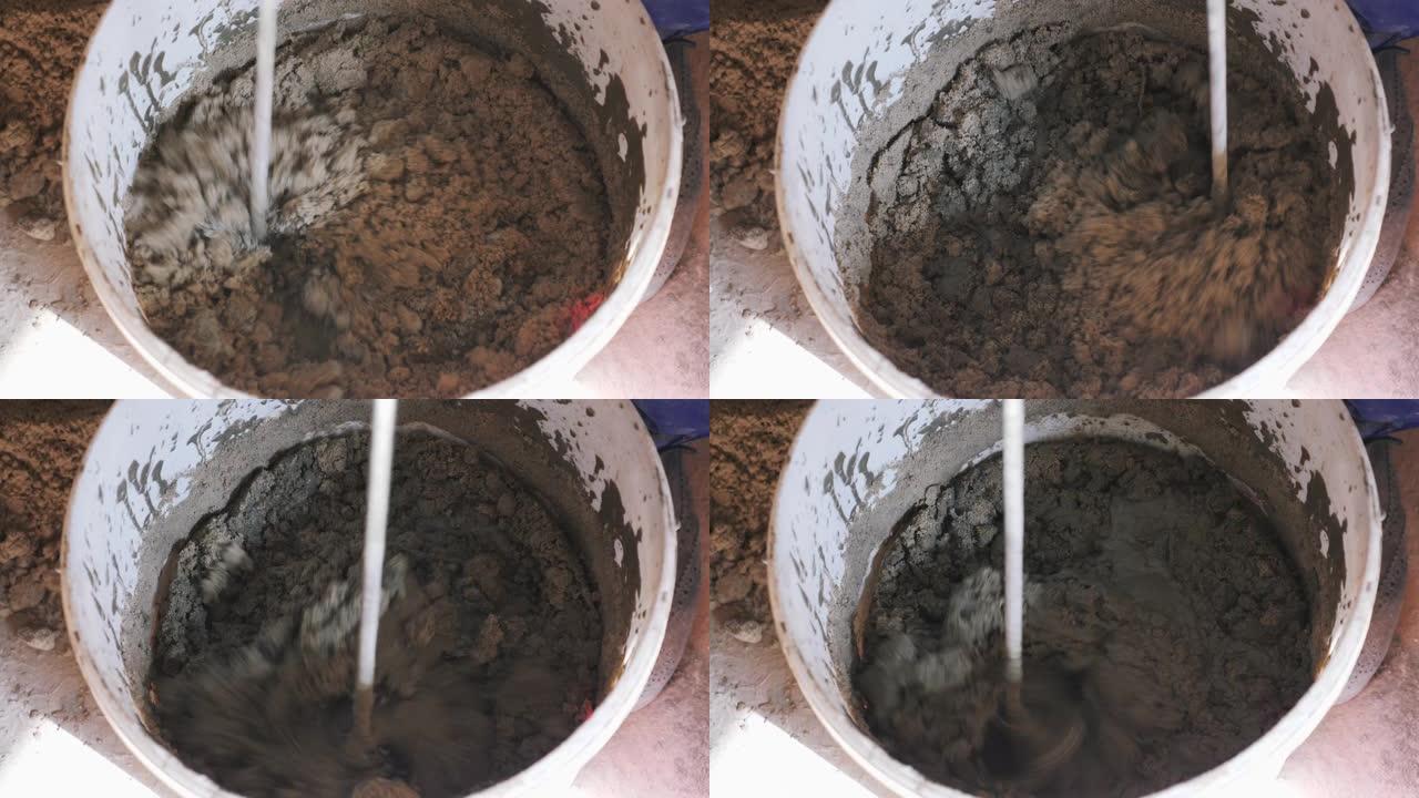建筑工人用水搅拌混凝土，用于建筑。关闭砂浆桶中的混合水泥