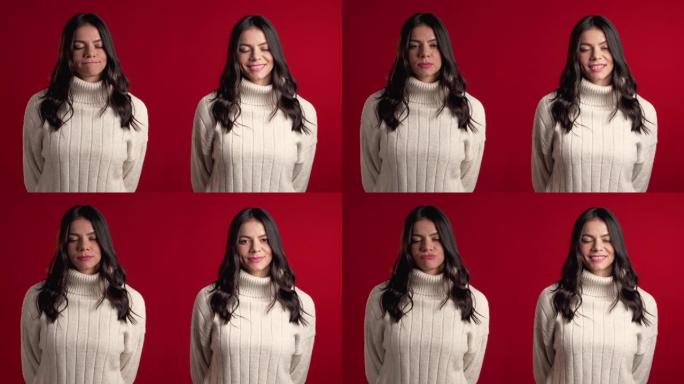 工作室红色背景的年轻西班牙裔妇女穿着毛衣的肖像。女孩同时描绘了认可，同意和拒绝的情感，拼贴。4k