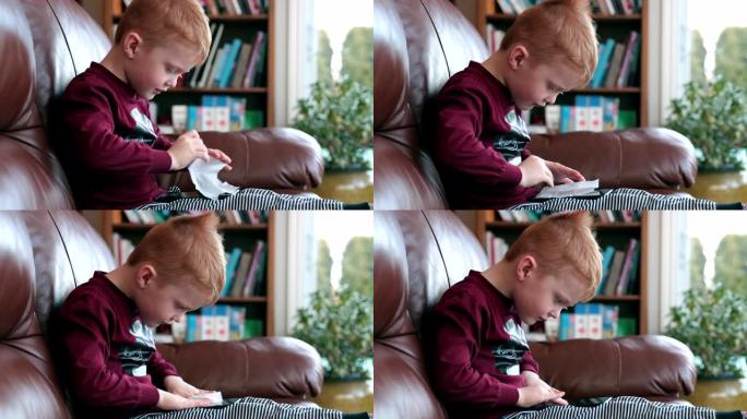 小男孩用抗菌一次性湿巾或纸巾清洁手机显示器