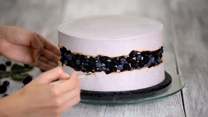 糖果用手工制作的金糖浆装饰浆果蛋糕。