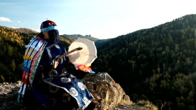 萨满巫师敲坐在山顶岩石上的手鼓。