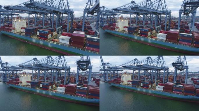 黄昏港口工作起重机和集装箱船，国际货运港，航拍视频