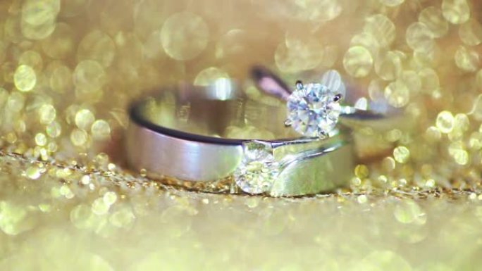 金色纹理背景的结婚戒指。婚礼主题。