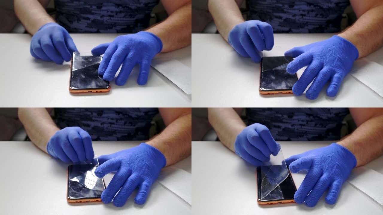 男性的手代替了智能手机的钢化玻璃屏幕保护膜。