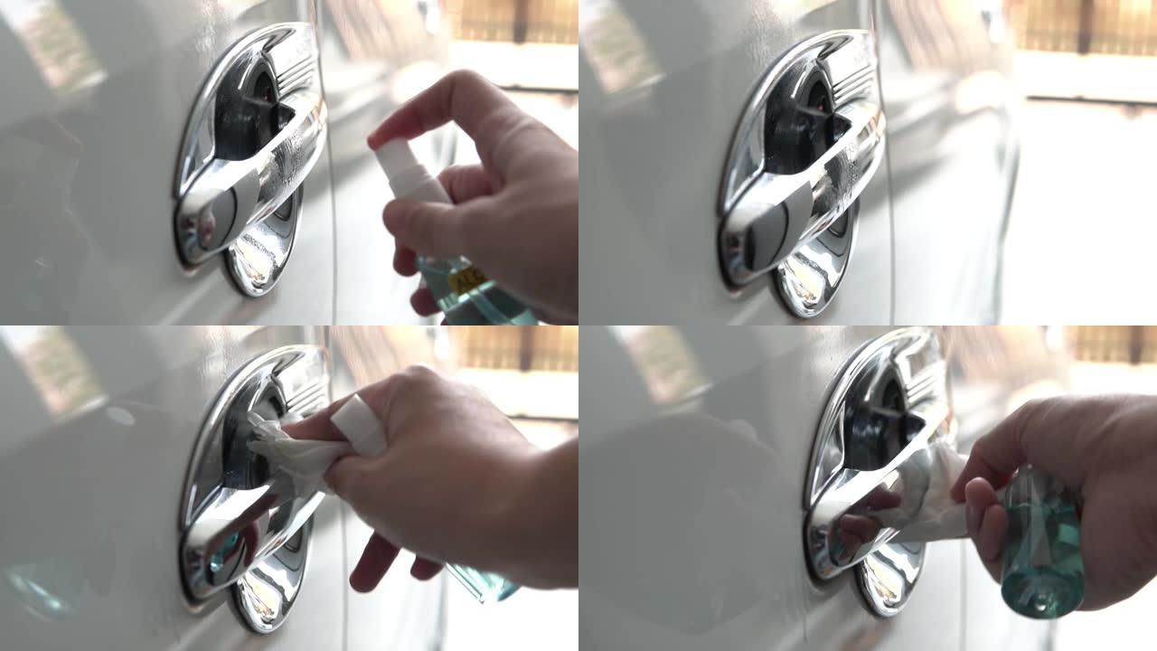 用酒精喷雾清洁新型冠状病毒肺炎病毒手擦拭汽车门把手表面。