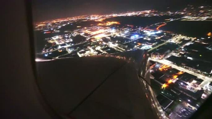 一架飞机在城市上空的夜间鸟瞰图