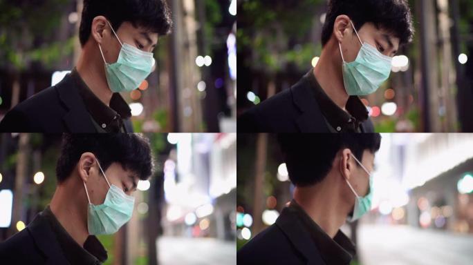 年轻的亚洲男子咳嗽与面罩保护在晚上