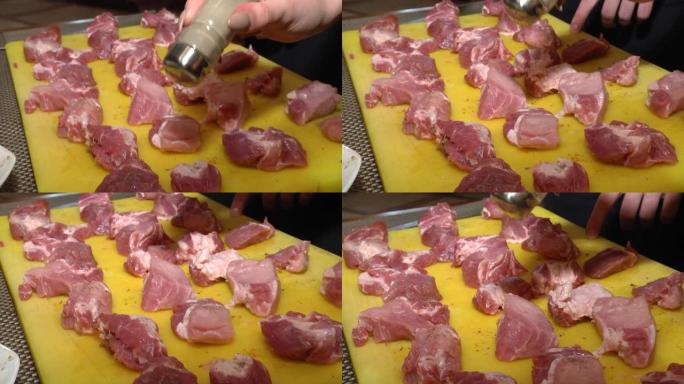 红肉小牛排，肉脂肪发白。一块肉躺在一块黄色的砧板上。厨师在切碎的肉块上撒上香料。