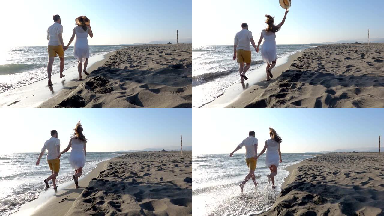 夫妇在靠近水的海滩上跑步很开心