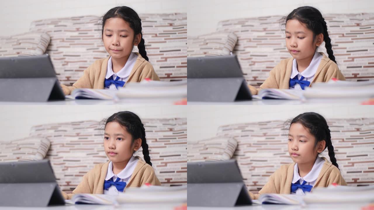 用快乐做作业的亚洲小女孩，穿着学生幼儿园制服的泰国女孩，在家学习教育