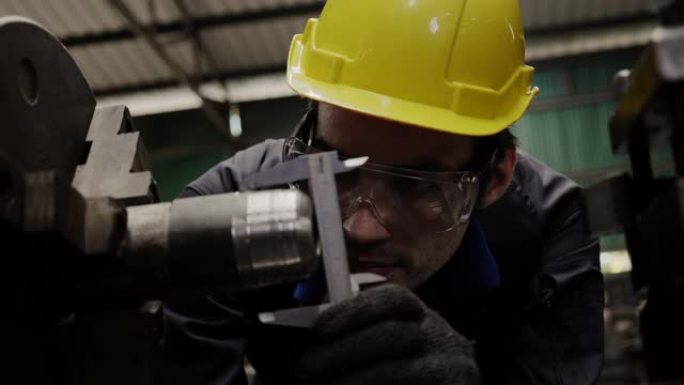 工程师工人戴上黄色安全帽，使用工具检查和维修工厂中的机器状况，以准备生产。职业和意外保险概念