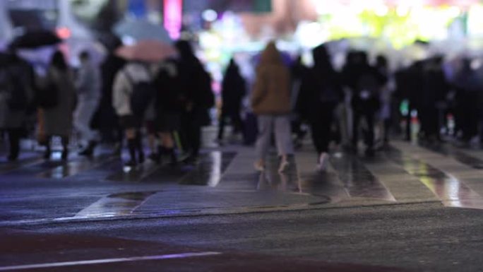 晚上在新宿东京下雨天在十字路口散步的人