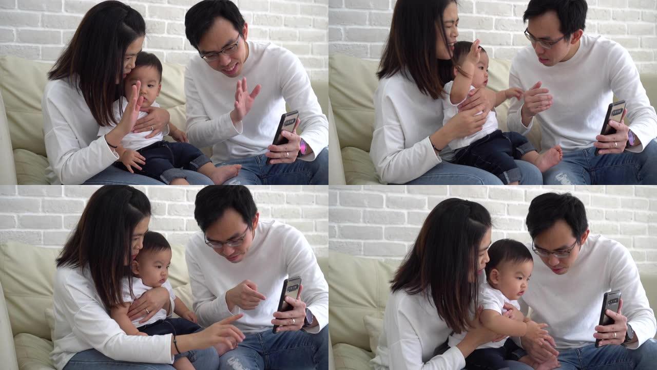 快乐的亚洲家庭在家打视频电话。父亲和母亲，儿子向呼叫者挥手