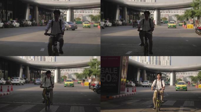 英俊的年轻人在城市的街道上驾驶自行车
