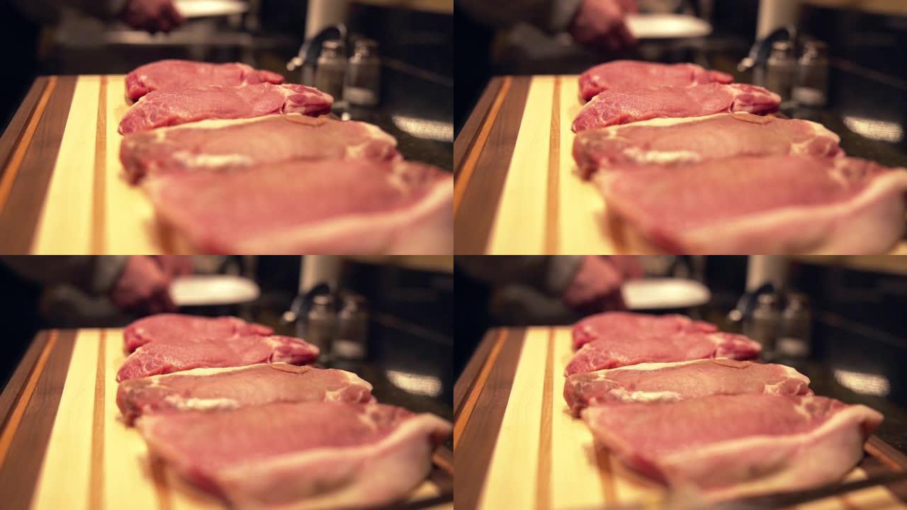 在准备烧烤的木制砧板上新鲜的未煮熟的生去骨里脊肉猪排的移动镜头的背景下洗手