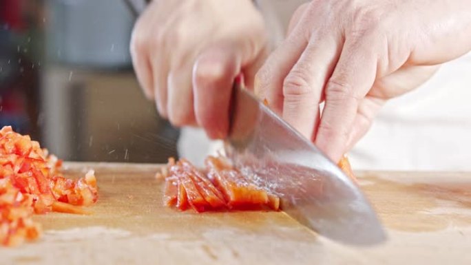 厨师刀切成红色甜椒的慢动作特写