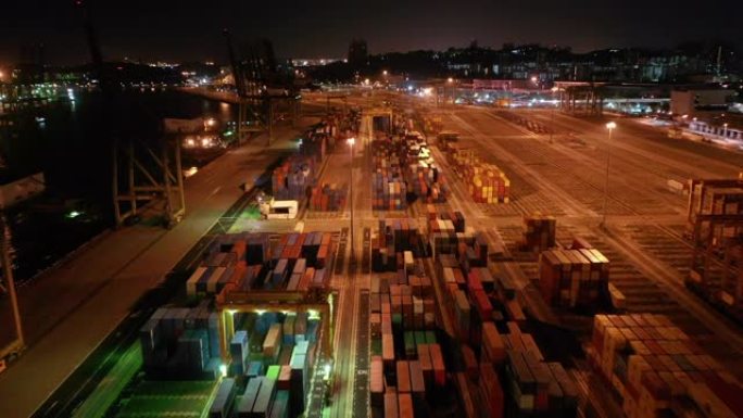 无人驾驶飞机拍摄了一艘货船坐在长滩港的码头上，起重机吊杆下降到适当的位置以卸下集装箱。